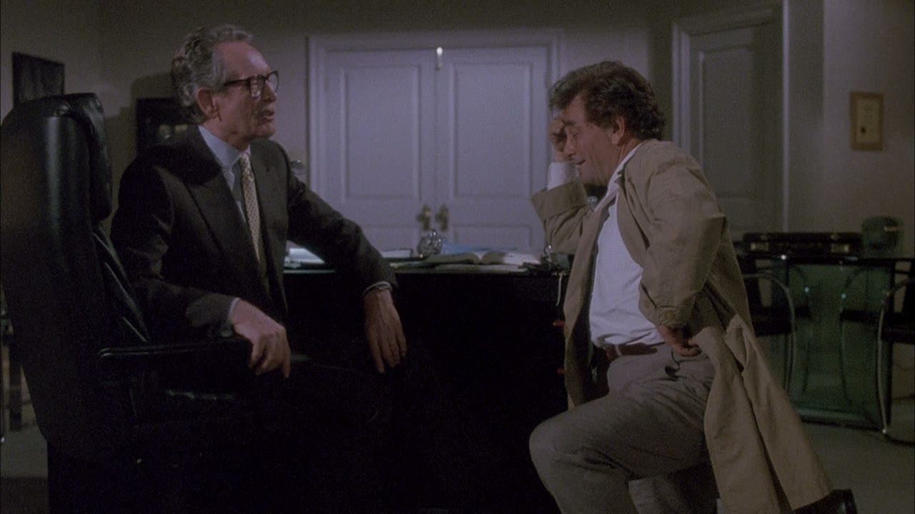 A conversation in an office hung with commendations